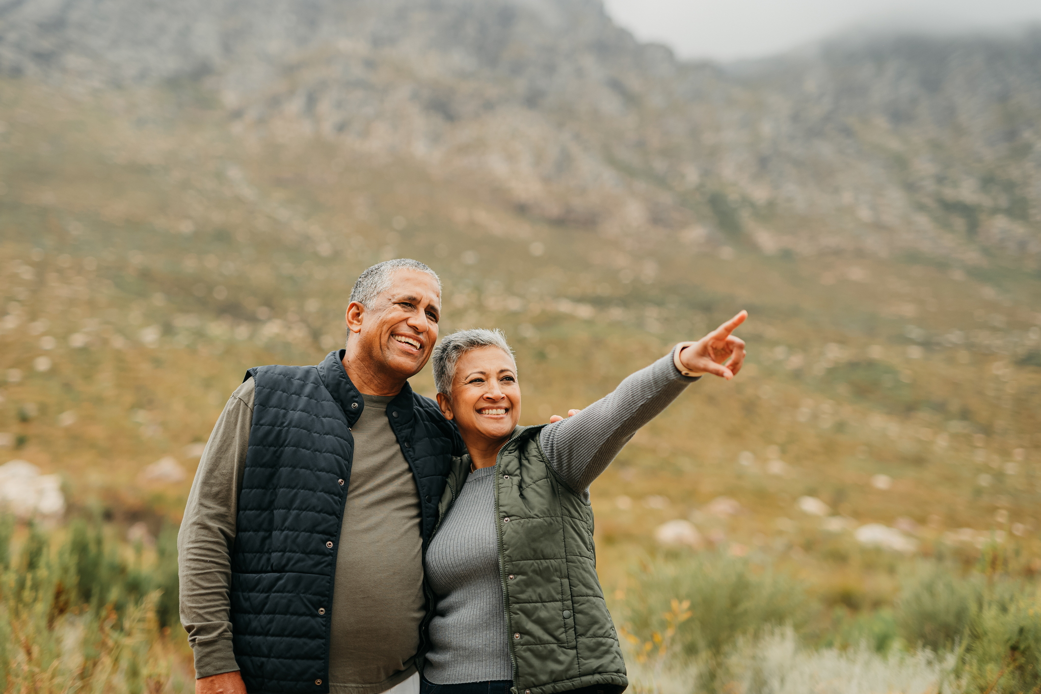 Hiking, couple and view with a senior man and woman in nature for a hike and enjoying the outdoor adventure. Elderly married people exploring a natural environment in the mountain or wilderness
